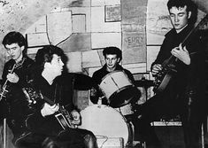 three men are playing instruments in an old photo