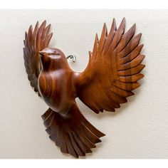 a wooden bird mounted to the side of a wall