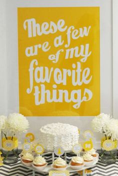 a table topped with cupcakes and cake next to a yellow sign that says, these are a few of my favorite things