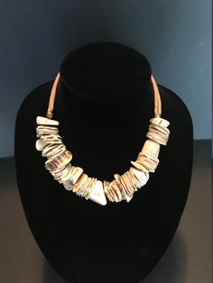 "Vintage Necklace Shell and Antler Natural Elements Design Gold Fill Primitive Beach Jewelry, 17 Inches This vintage necklace is a perfect accent to any summer outfit. It is largely made of natural elements and although large and impressive it also has an easy, beach life look. The 17 Inch necklace is centered with over 8 Inches of coin shells and antler which are center drilled and strung intermittently. The middle section is joined to two rope braids on both sides which connect securely with a Artisan Adjustable Natural Necklace, Artisan Adjustable Natural Color Necklaces, Artisan Adjustable Natural Necklaces, White Adjustable Earthy Necklace, Adjustable White Earthy Necklace, White Adjustable Earthy Necklaces, Adjustable White Earthy Necklaces, Unique Adjustable Natural Color Necklace, Adjustable Beige Necklace For Vacation