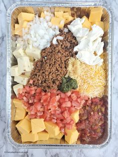 a plastic container filled with lots of different types of cheese and toppings on top of it