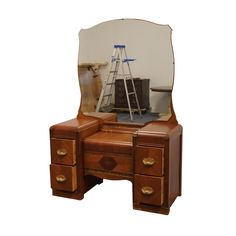 a wooden desk with a mirror and a ladder on it's side, in front of a white background