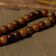 This wrist mala is made of bodhi root, a symbol of enlightenment and spiritual awakening. Bodhi root beads are considered to be sacred in Tibetan culture, and are believed to bring peace, prosperity, and spiritual enlightenment. The earthy colors of the beads, including brown, green, and natural tones, are inspired by nature and bring a grounding energy to your meditation. · Material: Bodhi Root · Thread: Cotton· Size: 13mm· Process: Handmade (Up to three days)· Package: Eco envelop The handmade Tibetan Culture, Grounding Energy, Wrist Mala, Tibetan Buddhism, Spiritual Enlightenment, Earthy Colors, Natural Tones, Three Days, Spiritual Awakening