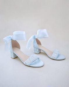 a pair of white shoes with bows on them