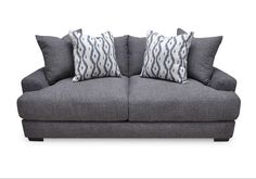 a gray couch with two pillows on top of it and another pillow in the back