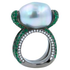 12.15 Carats Beautiful Silvery White Iridescent South Sea Pearl 16.50 x 13.50 mm Elongated Egg Oval Shape South Sea Pearl Size AAA Quality Extremely Beautiful, Captivating Pearl High-End, Luxury Crafting & Finish Green Emeralds Pave: 3.00 ctw Blue Sapphires Pave: 0.50 ctw White Diamonds Pave: 0.50 ctw 18K White Gold + Black Rhodium Plating 14.7 grams Ring Size 5.75 Sea Pearl, 18k Gold Ring, Sea Pearls, South Sea Pearls, Pearl Size, Emerald Diamond, Cocktail Rings, Pave Diamonds, Earings Piercings