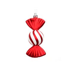 a red and white christmas ornament hanging from a string on a white background