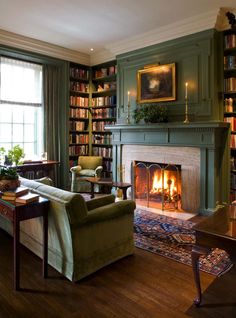 a living room filled with furniture and a fire place in front of a book shelf