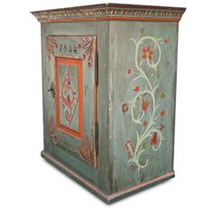 an old painted cabinet with flowers and vines on the door is isolated against a white background