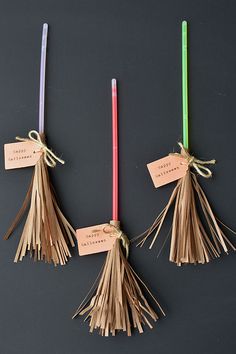 three tasseled candles with tags attached to them