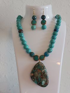 Natural Ocean Impression Jasper/Pyrite free-form pendant.  Natural Grage AAA turquoise 10mm beads. 2 round gold trimmed turquoise  accent beads. Matching hypo allergic gold dangle earnings Turquoise Beaded Necklace, Necklace Matching, Turquoise Accents, Turquoise Bead Necklaces, Ocean Blue, Turquoise Beads, Earrings Set, Chain Styles, Matching Earrings