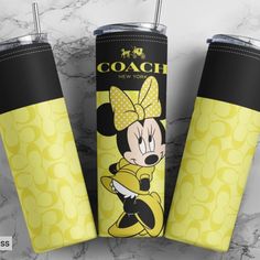 two mickey mouse tumblers sitting next to each other on a marble surface with the word coach printed on it