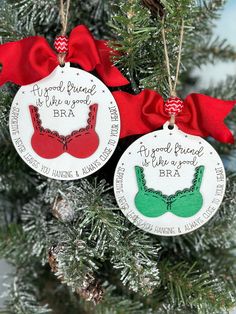 two christmas ornament ornaments hanging from a tree with red and green bows on it