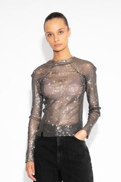 This Crystal Embellished Fishnet Long-Sleeved Top exudes an ultra-feminine aesthetic. With its impeccable craftsmanship, brilliant crystal embellishments, and daring design, this top is perfect for making a provocative and sophisticated statement. Hand sewn Centre back zip  All-over crystals Length: 56cm The model is 5ft 9 and wears a size small Gentle Dry Clean Chic Shiny Tops For Party Season, Chic Metallic Tops With Shine Detail, Chic Metallic Shine Tops, Chic Embellished Fall Tops, Glamorous Shiny Tops For Night Out, Chic Shiny Tops For Night Out, Chic Tops With Shine For Night Out, Shiny Evening Top For Spring, Elegant Shiny Tops For Night Out