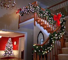 a staircase decorated for christmas with lights and garland on the bannister railings