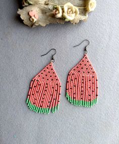 two pairs of beaded earrings sitting next to each other on top of a table