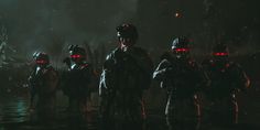 some people standing in the dark with red lights on their face and one person wearing a helmet