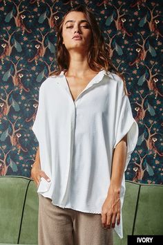 Stay comfortable and stylish in our Oversized Dolman Top. Featuring a collared button-down front and short drop-shoulder sleeves, this loose-fitting top is perfect for any occasion. Its curved hi-low hemline and textured lightweight woven fabrication add unique details to this must-have shirt. • Fabric: 100%POLYESTER First model wearing a medium 5'4 Effortless Blouse With Rolled Sleeves And Shirttail Hem, Effortless Button-up Blouse With Rolled Sleeves, Oversized Versatile Daywear Blouse, Oversized Versatile Blouse For Daywear, Versatile Oversized Blouse For Day, Oversized V-neck Blouse With Button Closure, Oversized Effortless Blouse For Day Out, Effortless Oversized Blouse For Day Out, Chic Summer Tops With Curved Hem