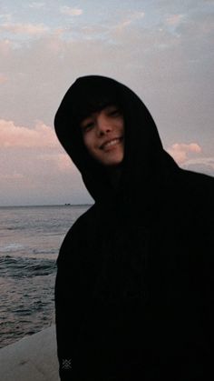 a man standing on top of a beach next to the ocean