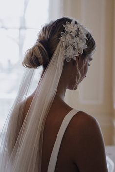 a woman wearing a veil with flowers in her hair