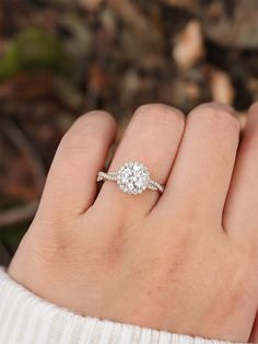 a woman's hand with a diamond ring on top of her finger and an engagement band