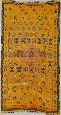 an old yellow rug with many different designs