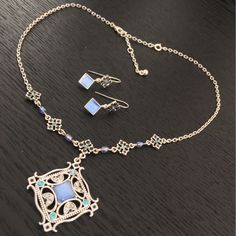 Vintage Avon Blue Moonglow Pendant Necklace And Earring Set Silver Tone Signed This is a stunning vintage Avon jewellery set. The design is an exquisite ornate silver tone square base set with blue moon glow glass and teal rhinestones. The chain is decorated with smaller squares with blue beads in between. Complete with 2 drop earrings that match. Good vintage condition. Have a look at how good this looks when layered with the moonstone beaded necklace available in store separately.  For size an Elegant Nickel-free Square Pendant Jewelry, Vintage Silver Jewelry Sets With Matching Earrings, Vintage Silver Square Jewelry, Avon Vintage, Avon Jewelry, Moonstone Beads, Moon Glow, Necklace And Earring Set, Vintage Avon