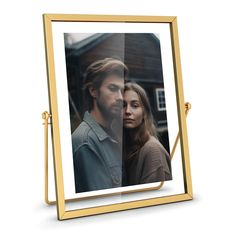 a gold frame with an image of a man and woman in the reflection on it