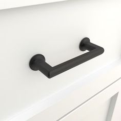 a black handle on a white cabinet door