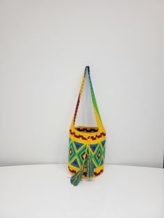 Original Wayuu bag handmade in Colombia by the women of the Wayuu tribe. Unique bag with a unique design in each one, with large capacity. Perfect to wear to the office, school, dates, travel or any other daily occasion. The Wayúu are best known for the beautiful and colorful crochet fabrics created by women. They even have a popular saying: "To be a woman is to know how to knit." Measures: Height: 11 1/2 inches. Diameter: 9 inches. Strap length: 49 inches. Washed: Wash in cold water with mild soap. Do not machine wash. Dry in sunlight. Multicolor Pouch Bag For School, Multicolor School Pouch Bag, Multicolor Large Capacity Crochet Bucket Bag, Multicolor Large Capacity Bucket Crochet Bag, Green Bucket Bag Backpack For Daily Use, Bohemian Bucket Bag Satchel Style, Bohemian Bucket Shoulder Bag, Artisan Multicolor Bucket Bag For Daily Use, Casual Handwoven Shoulder Bag For Festivals