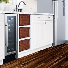 a kitchen with white cabinets and wooden flooring next to a wine cooler in the center