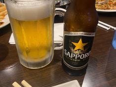 a beer and chopsticks on a table