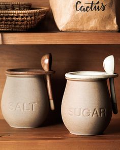 two salt and pepper shakers sitting on top of a wooden shelf