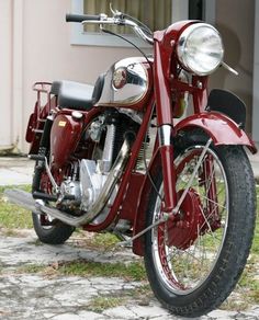 a red motorcycle parked in front of a building