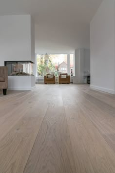 an empty living room with white walls and wood floors