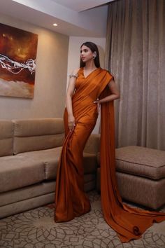 Charmeuse silk in this shade of burnt orange creates depth and a regality that is sure to impress with an updated feel on the traditional sari Keep it muted and elegant for added focus on the cut or pair it with bold jewellery for a dramatic look Elegant Art Silk Pre-draped Saree With Cutdana, Elegant Formal Art Silk Pre-draped Saree, Orange Pre-draped Saree With Unstitched Blouse For Party, Festive Satin Pre-draped Saree For Formal Occasions, Elegant Silk Pre-draped Saree For Diwali, Elegant Silk Pre-draped Saree With Cutdana, Orange Pre-draped Saree For Diwali, Silk Pre-draped Saree With Zari Work For Formal Occasions, Formal Silk Pre-draped Saree With Zari Work