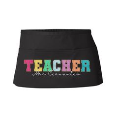 a black teacher apron with the word teacher in multicolored letters on it's front