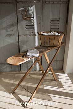 an old ironing board with a basket on it