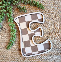 the letter e is made out of wood and has a checkerboard pattern