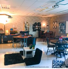 a room filled with lots of chairs and tables in front of a wall mounted clock