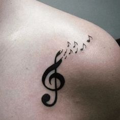 a woman's chest with musical notes tattoo on her left side ribcage