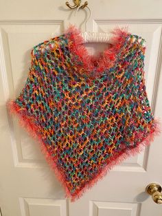 Add a touch of bohemian style to your little girl's outfit with this beautiful handmade poncho shawl. The pink and multi color and fringe accents give it a playful and fun look that is perfect for travel or casual occasions. The round neckline and pullover closure make it easy to wear and comfortable for all-day wear. Made with care in the United States, this sweater is a one-of-a-kind piece that your little girl will love. The crochet fabric type adds texture and interest to the garment, while the vintage style gives it a unique touch. It measure 25 inches wide and 22 inches in length. The head opening is 24 inches. Perfect for girls of all ages, this cape-style sweater is a must-have addition to any wardrobe. Hippie Poncho With Tassels One Size, Hippie Tassel Poncho One Size, One Size Tasseled Shawl For The Beach, Beach Shawl With Tassels, Beach Shawl With Tassels One Size, Multicolor Beach Shawl For Spring, Spring Beach Shawl In Multicolor, One Size Beach Shawl With Fringe, Multicolor One-size Festival Poncho