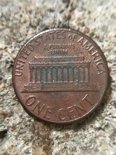 a penny sitting on top of a rock