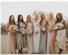 a group of women standing next to each other wearing dresses and holding bouquets in their hands