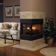 a living room filled with furniture and a fire place next to a white couch on top of a hard wood floor