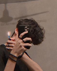 a man taking a selfie in front of a mirror with his cell phone up to his face