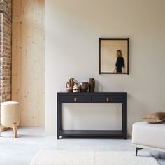 a living room with a couch, table and pictures on the wall