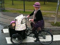 an older woman pushing a stroller with a child in it