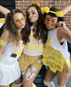 three girls in yellow and white outfits posing for the camera