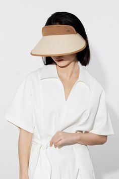 Sleek Minimalism Meets Superior Sun Protection This sun visor combines 100% paper straw and cotton-linen for a breathable and stylish finish. Its wide brim offers excellent sun protection, while the inner layer ensures UPF 50+ coverage. The raised front visor and adjustable elastic back strap provide both functionality and style. Style #: WWAJ528 Classic Summer Sun Hat With Visor, Modern Curved Brim Hats For Summer, Modern Summer Hat With Curved Brim, Classic Panama Visor Hat For Summer, Classic Visor Panama Hat For Summer, Modern Brimmed Summer Hats, Spring Brimmed Visor With Upf 50+, Modern Beach Hats For Summer, Modern Brimmed Panama Hat For Summer